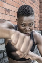 Black athlete punching outdoors