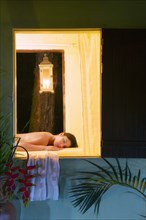 Hispanic woman laying on massage table in spa