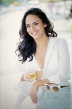 Hispanic woman drinking cocktail outdoors