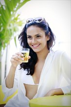 Hispanic woman drinking cocktail outdoors