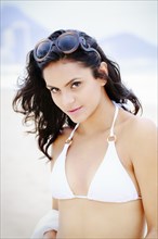 Hispanic woman wearing bikini on beach