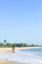 Mixed race woman walking on beach