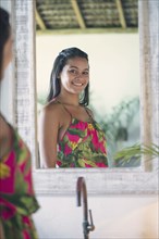 Mixed Race girl smiling in mirror