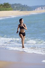 Mixed Race girl running on beach