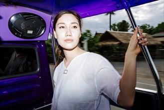 Mixed Race woman riding bus in Bangkok