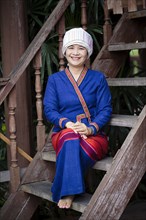 Asian woman wearing traditional clothing sitting on staircase