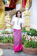 Smiling Asian woman standing in ornate garden