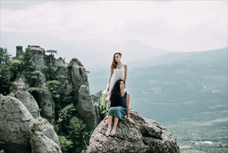 Women on rock overlooking landscape