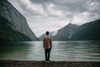 Caucasian man standing near mountain lake