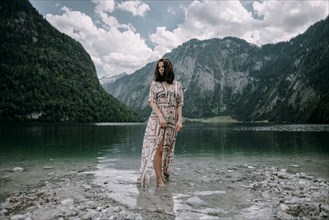 Caucasian woman wading in near mountain lake