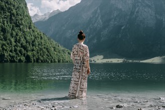Caucasian woman wading in mountain lake