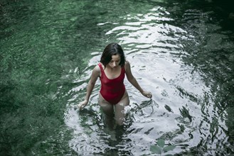 Caucasian woman wading in pool of water