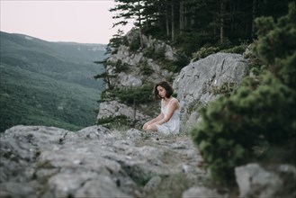 Sad Caucasian woman sitting on mountain