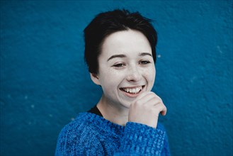 Smiling Caucasian woman near blue wall