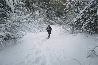 Caucasian woman hiking in snowy forest