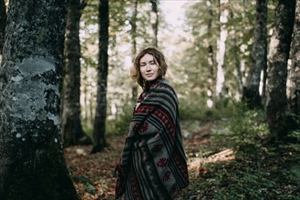 Caucasian woman wearing shawl in forest