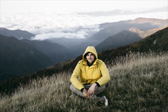 Caucasian man sitting in remote mountain landscape