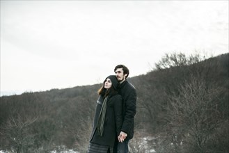 Caucasian couple standing on hill and relaxing