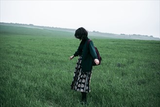 Caucasian woman standing in field of grass