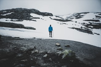 Distant Caucasian man hiking in winter