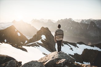 Caucasian man standing on rock admiring scenic view of mountain lake