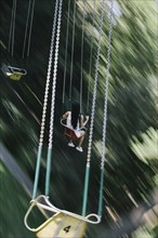 Woman riding amusement park swing