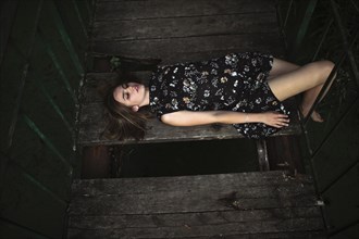 Caucasian woman laying on wooden bridge