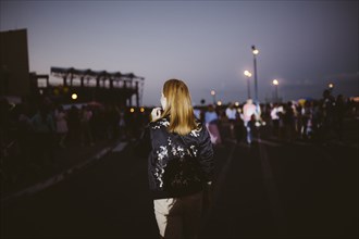 Rear view of Caucasian woman at night