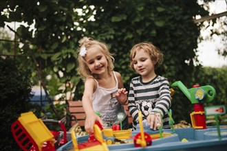 Caucasian boy and girl playing with toys outdoors