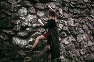 Caucasian woman climbing rock wall