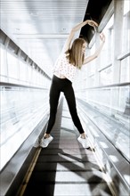 Caucasian woman dancing on moving walkway