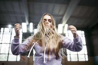 Caucasian woman jumping in gymnasium
