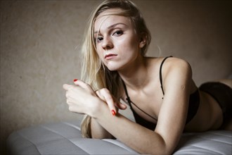 Close up of serious Caucasian woman resting on bed