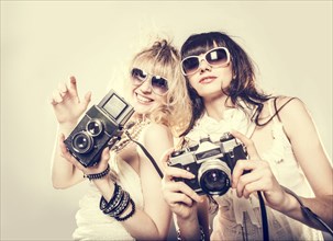 Caucasian women posing with cameras