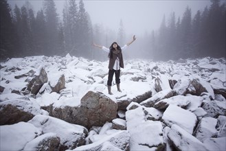 Caucasian woman standing on snow covered rocks