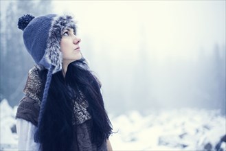 Caucasian woman standing in snowy woods