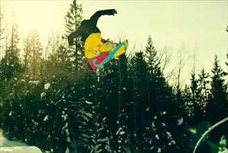 Caucasian man mid-air on snowboard