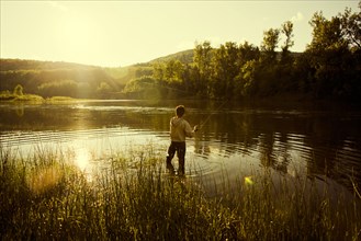 Caucasian man fishing in still lake