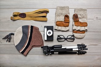 Photographer's equipment and clothing items arranged on floor