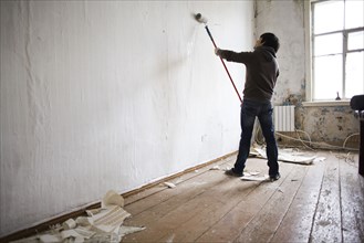 Mari man painting walls in new home