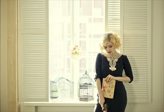 Caucasian woman holding book by window