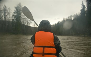 Mari man kayaking on river