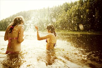 Girls splashing together in lake