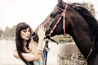 Caucasian woman petting horse outdoors