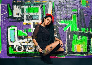 Woman posing in front of colorful graffiti wall