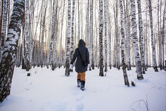 Caucasian woman walking in snowy forest