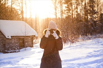 Caucasian woman photographing in snow