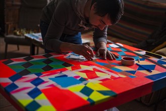 Mari man designing colorful table