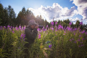 Mixed race photographer photographing flowers