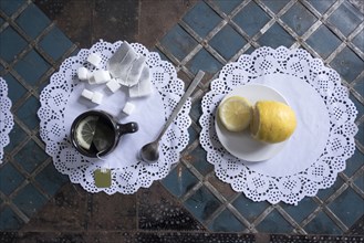 Cup of tea with lemon and sugar on lace doilies